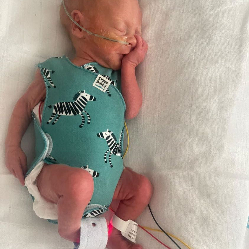 premature baby wearing zebra nicu vest